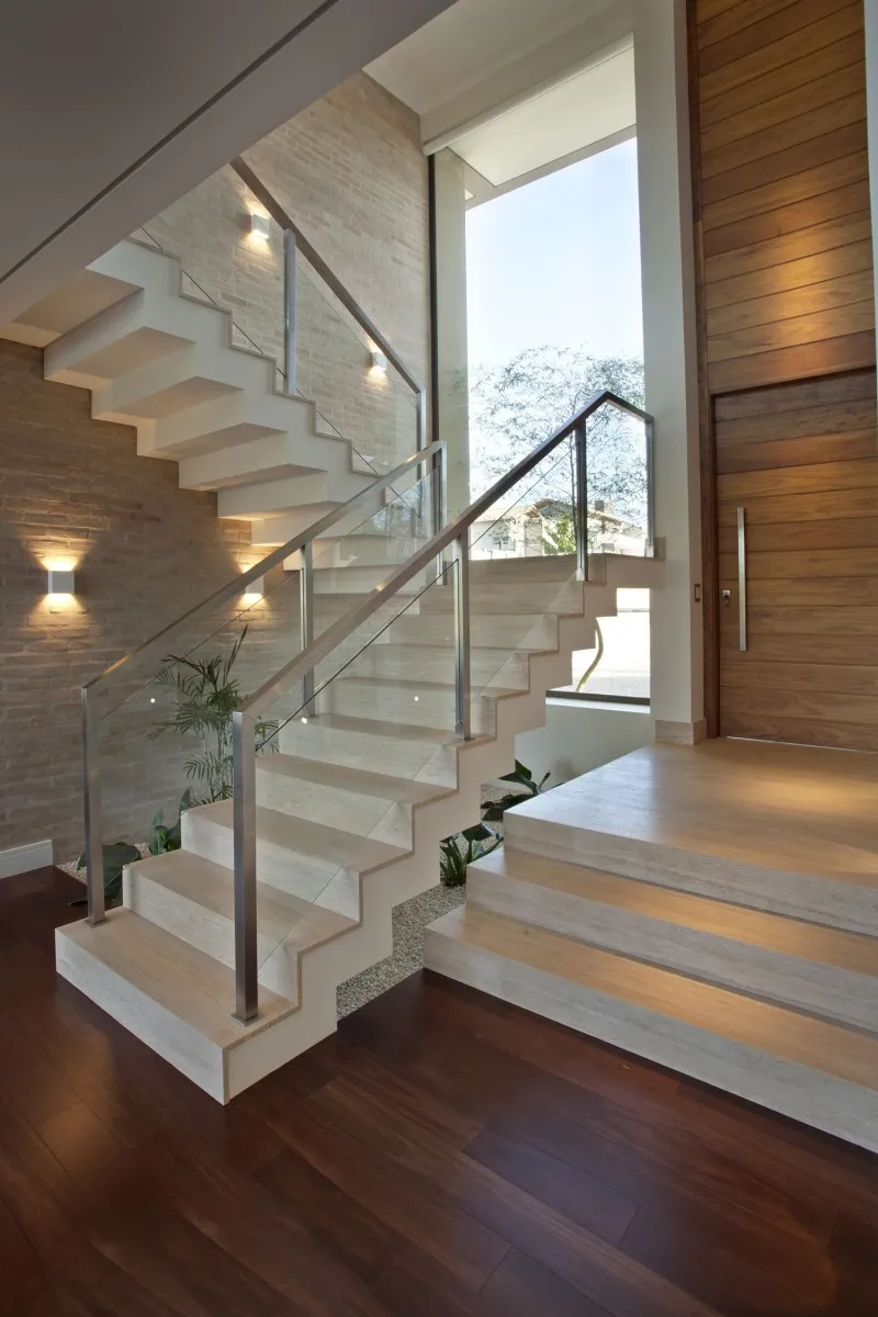 Cầu thang chữ U với các bậc thang lát gỗ và tay vịn bọc thép mang đến sự hài hoà về màu sắc trong không gian nhà ở.