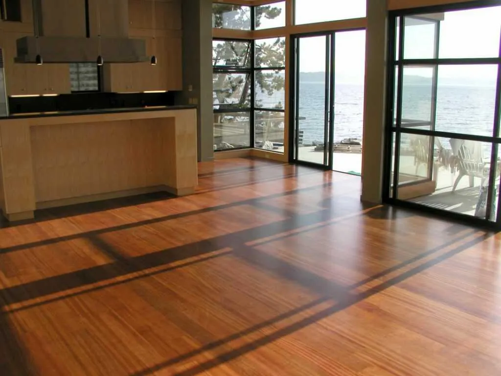 Sàn gỗ tự nhiên tone màu nâu được lát trong phòng khách với thiết kế cửa kính độc đáo