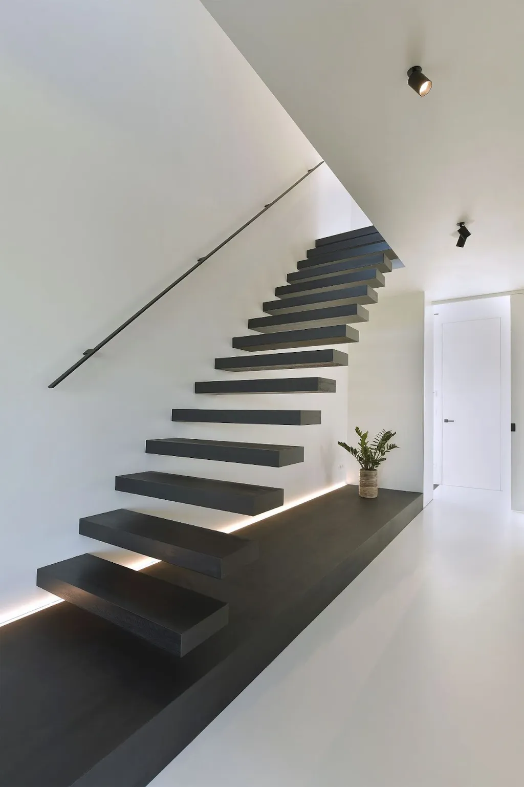 Tạo sự khác biệt cho ngôi nhà với những bậc thang lơ lửng trên không cùng bậc gỗ sơn gam màu tối giản hiện đại.