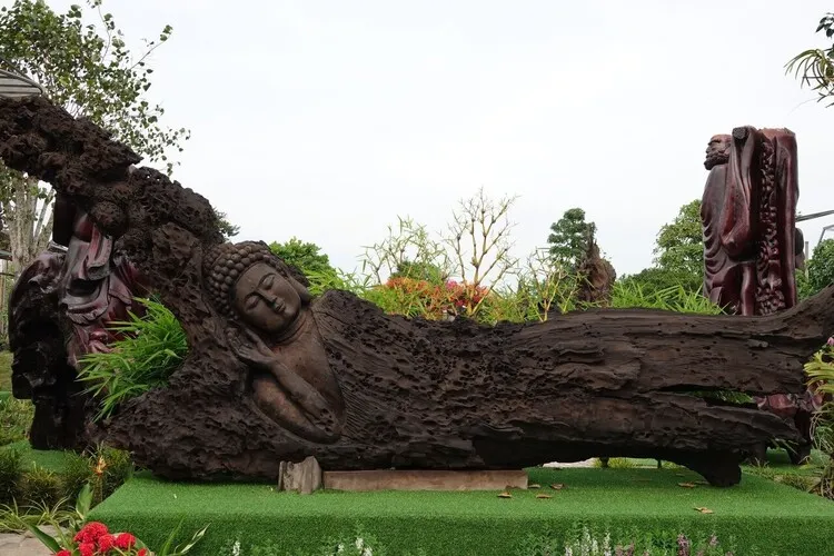 Tượng Phật nằm từ tấm gỗ lũa lớn tạo điểm nhấn hoàn hảo cho không gian sân vườn thêm sự thanh tịnh, thư thái.