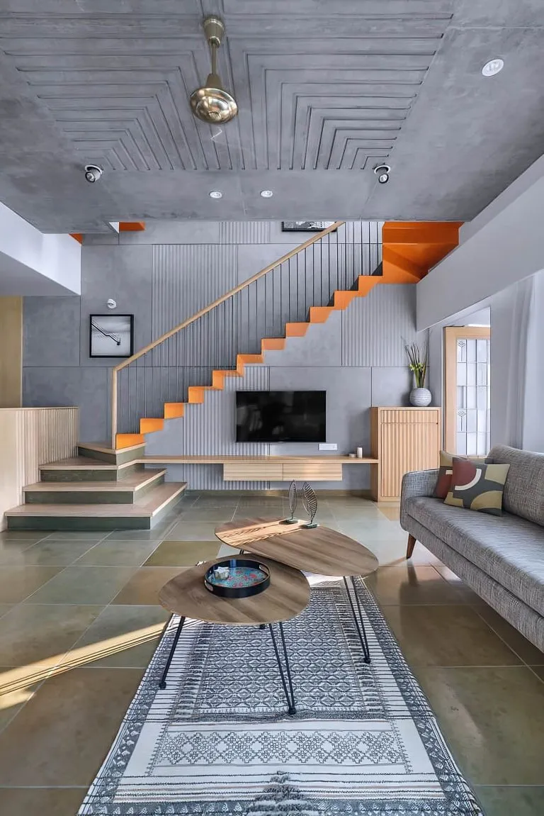 Cầu thang kim loại lan can kim loại với tay vin gỗ, kết hợp với màu sắc sơn cam xám, tạo nên một không gian rất bắt mắt và cuốn hút