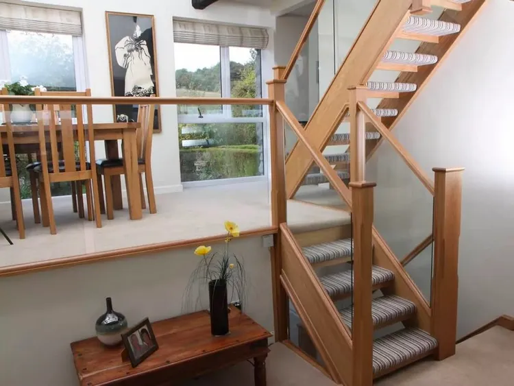 Cầu thang kính tay vịn gỗ có thiết kế linh hoạt và đa dạng, có thể tùy chỉnh để phù hợp với không gian và phong cách của ngôi nhà. Có thể thiết kế cầu thang với bậc cứng hoặc bậc cong, tùy thuộc vào sở thích cá nhân và kiến trúc nội thất.