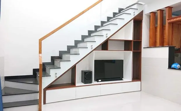 Cầu thang tay vịn kính được thiết kế sát tường có thể tạo nên không gian trống cho kệ tivi hoặc tủ kệ trữ đồ
