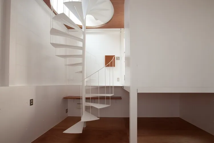 Cầu thang xoắn ốc phủ sơn trắng tinh thanh thoát đồng điệu với nội thất công trình. 