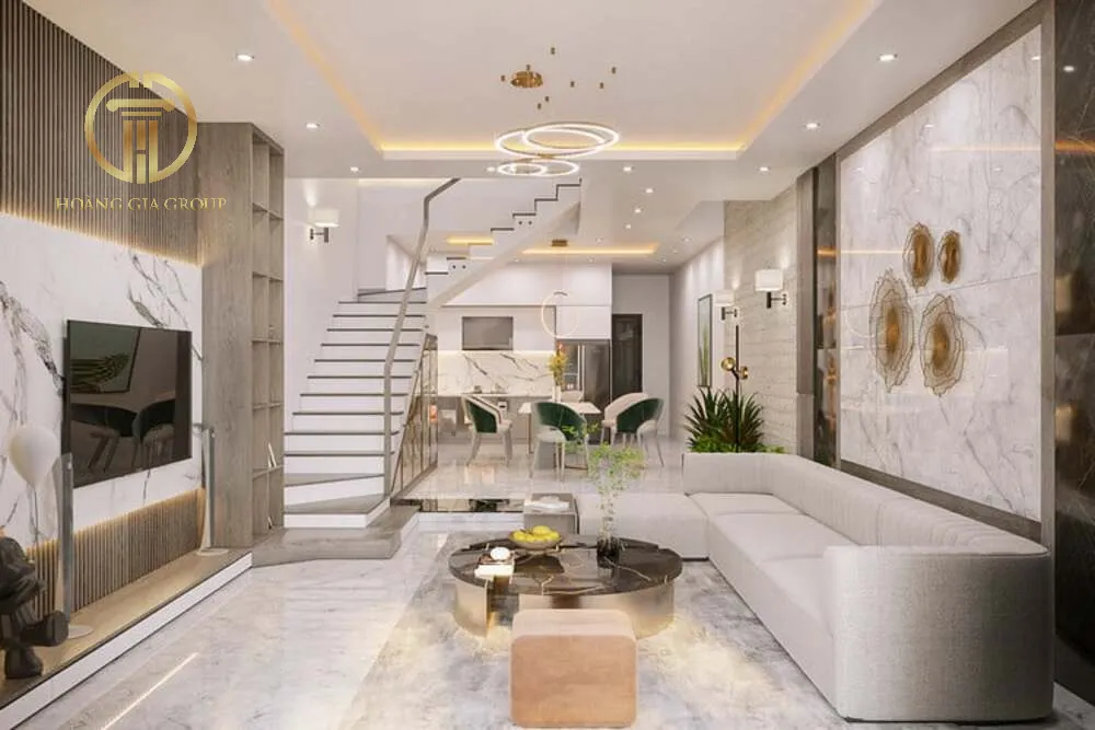Phòng khách có cầu thang với vách ốp đá trang trí cùng tone với sàn và tổng thể căn nhà tạo nên một không gian vô cùng hòa hợp và lộng lẫy