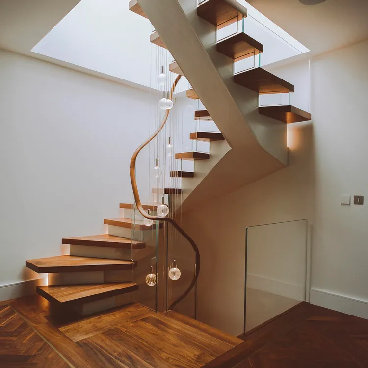 Sử dụng kính trong suốt trong thiết kế cho phép ánh sáng tự nhiên xuyên qua cầu thang, làm cho không gian trở nên sáng hơn và thoáng đãng hơn. Điều này cũng có thể tạo ra một cảm giác không gian rộng rãi hơn trong căn nhà.