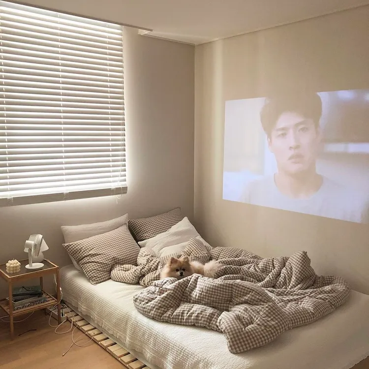 Trang trí phòng ngủ kiểu Hàn Quốc với dây đèn nhẹ nhàng đồng thời lắp đặt màn hình xem phim độc đáo và tiện lợi