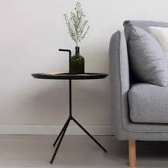 Bàn sofa nhỏ gọn, được sơn phủ tông đen. Mặt bàn tròn đều mỏng nhẹ với khung kim loại tạo hình như nắp ly nước đang cắm chiếc ống hút cực kỳ sáng tạo.