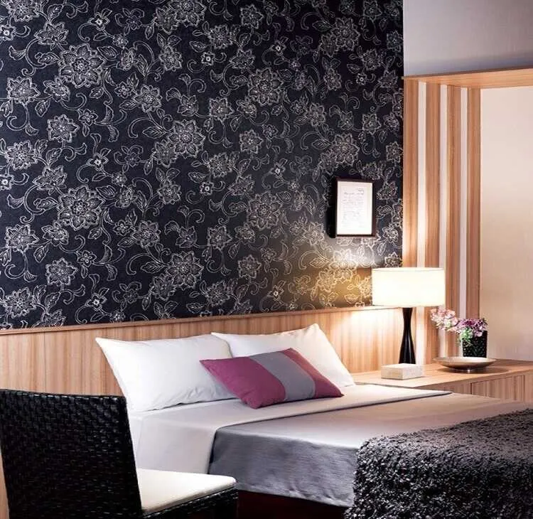 Giấy dán tường hoa văn đen trắng kết hợp các tấm ốp gỗ tạo vẻ đẹp gọn gàng, tối giản.