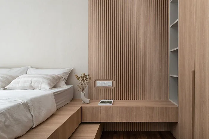 Giường ngủ được đặt trên một khung gỗ phẳng với tủ sách được thiết kế thông minh