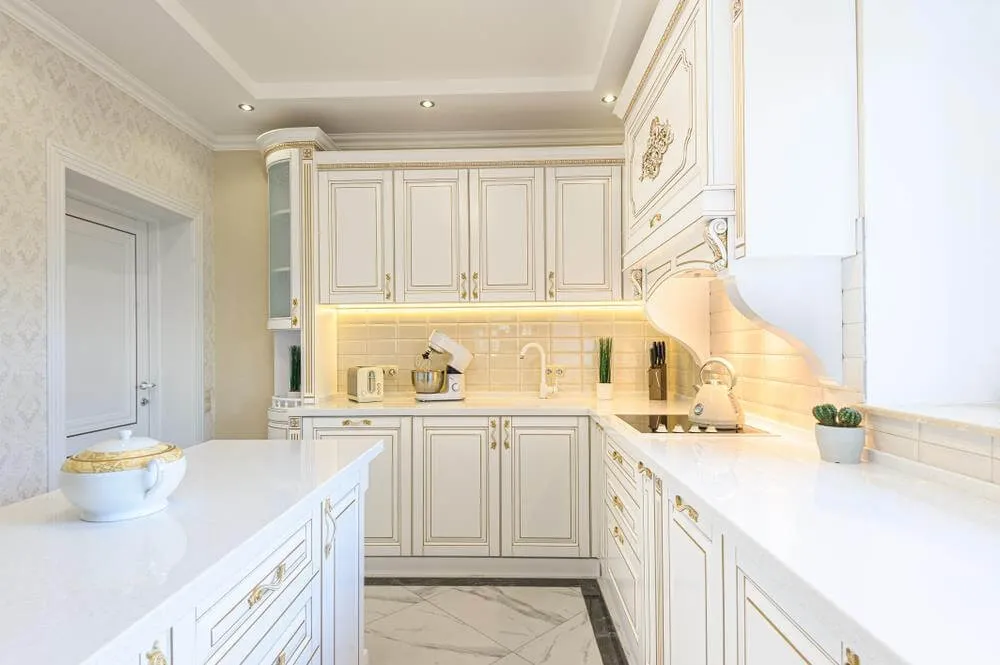 Phòng bếp tân cổ điển với tông trắng nổi bật, nhấn bằng các đường họa tiết màu trên tủ, kệ bếp