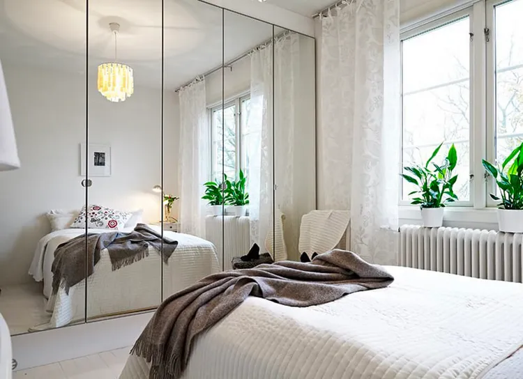 Đặt gương lớn hoặc gương treo tường trong phòng ngủ để tạo cảm giác không gian mở rộng hơn