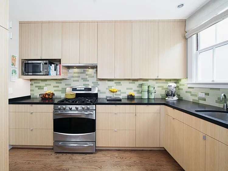 Tủ bếp nhựa laminate màu gỗ sáng nhẹ nhàng kết hợp mặt bếp ốp đá tối màu, tạo nên sự hài hoà, sạch sẽ.