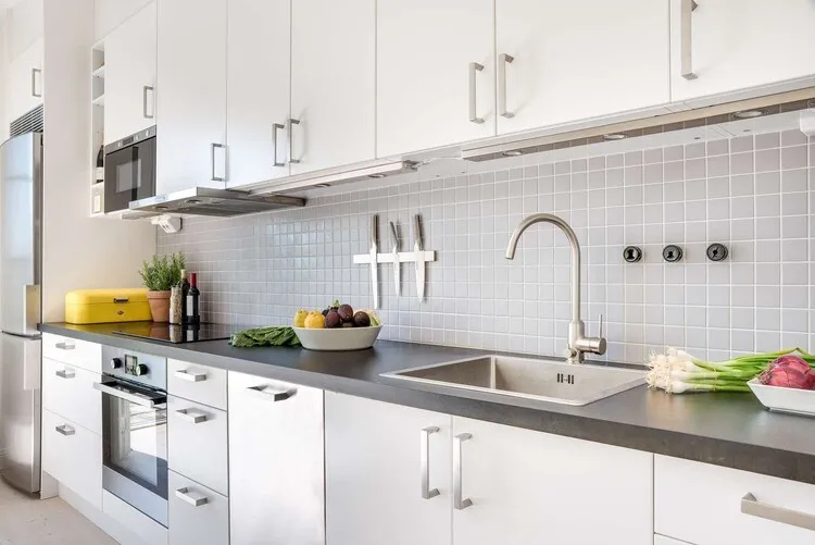 Tủ bếp PVC màu trắng với tay nắm kim loại cùng tông mang tới sự nhẹ nhàng, sang trọng cho gian bếp.