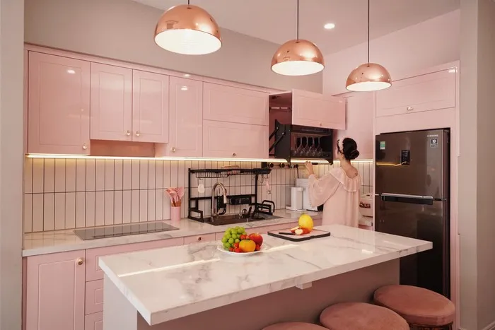 Tủ bếp acrylic màu hồng phối đảo bếp và nội thất cùng tông