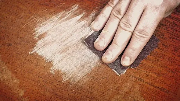 Sử dụng giấy nhám đề chà loại bỏ mốc trên gỗ