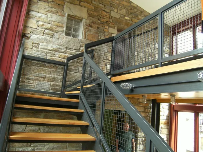 Mẫu cầu thang sắt đẹp với lan can thiết kế lưới vuông kết hợp bậc thang gỗ