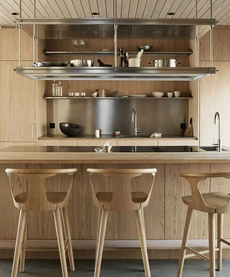 Quầy bar bếp với ghế ngồi, tủ bếp 100% từ gỗ ton-sur-ton, sử dụng kính tối màu ốp trên mặt bàn vừa tạo điểm nhấn vừa tăng sự sang trọng, sạch sẽ.