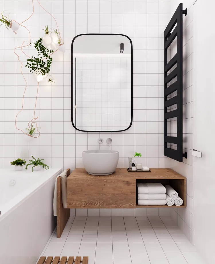 Lắp đặt một tấm gương lớn hoặc một bức tường kính để tạo cảm giác không gian mở và phản chiếu ánh sáng, tạo độ sâu cho phòng tắm.