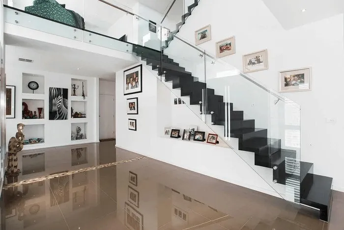 Cầu thang inox phối lan can kính cường lực trong suốt trong không gian nội thất hiện đại